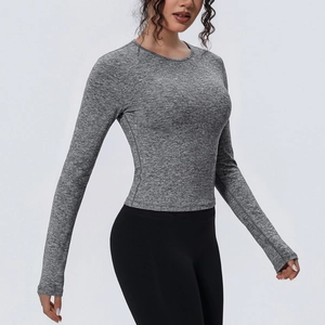 Détail du haut de yoga gris moulant montrant la texture du tissu élastique et respirant