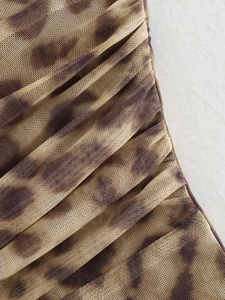 Close-up of leopard print mesh fabric featuring intricate ruched and pleated details