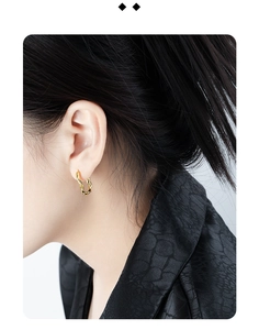 Close-up of golden irregular wave earrings on model showing minimalist aesthetic