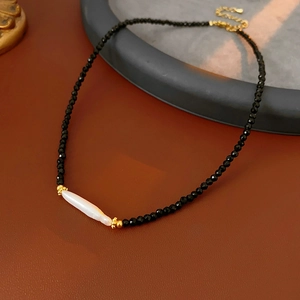 Macro detail of vintage French necklace with black agate beads and freshwater pearl accent