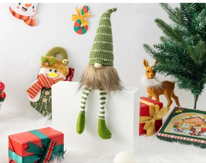 Detailed view of a Christmas gnome figurine with striped legs and a green knitted hat decor