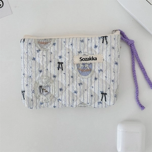 Detailed view of floral quilted cotton pouch with light blue stripes and purple zip pull