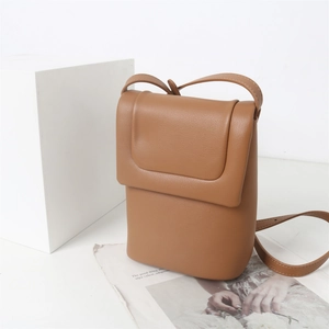 Vue détaillée du sac bandoulière en cuir marron sur un fond esthétique et élégant