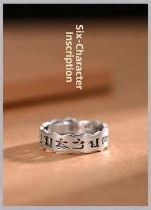 Macro detail of silver Sanskrit ring showing engraved Six-Syllable Mantra and wavy edges