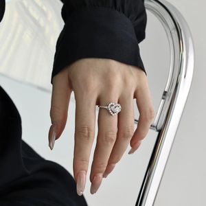 Close-up of S925 sterling silver heart ring with sparkling zircons on a model hand