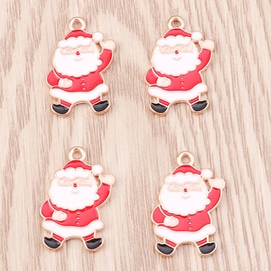 Detailed view of four Santa Claus alloy pendants with red and white enamel on wood
