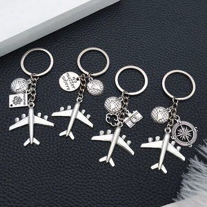 Detailed travel keychain set featuring silver globe, airplane, and passport metal charms