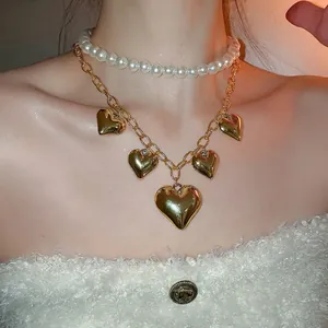 Double-layer pearl and gold chain necklace with five polished heart-shaped pendants