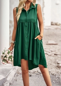 Détail d'une robe chemise verte sans manches avec ourlet asymétrique et poches latérales