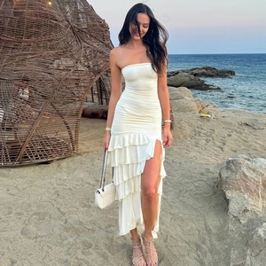 Detail view of white strapless layered dress with ruffled hem and side high split design