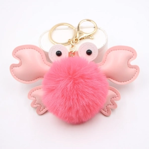 Detail of pink crab plush keychain with soft pom pom and golden metal swivel clasp hook