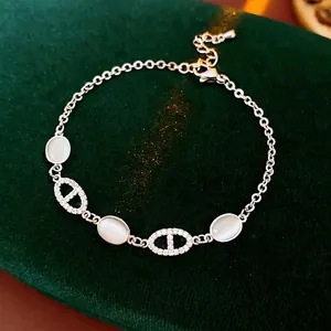 Bracelet argenté avec pierre œil de chat ovale et zircons sur fond de velours vert