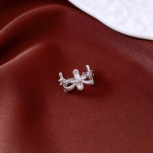 Detailweergave van zilveren ring met witte zirkoon op donkerrode zijde achtergrond