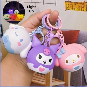 Detailed view of hand-held Sanrio glowing keychains with Cinnamoroll and Kuromi designs