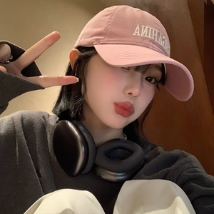 Pink baseball cap with white embroidery and headphones in a stylish lifestyle selfie