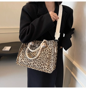 Detail of leopard print canvas tote featuring dual handles and a wide fabric strap