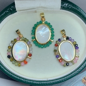 Pendentifs Vierge Marie en nacre avec dorure et cristaux colorés dans un écrin à bijoux