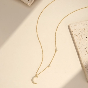 Macro detail of gold-plated moon and star necklace with micro-pave cubic zirconia crystals