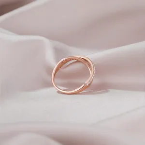 Rose gold interlocking ring with Roman numerals and sparkling cubic zirconia stones