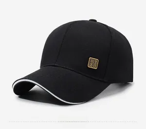 Close-up of black cotton baseball cap with gold metal badge and white brim piping