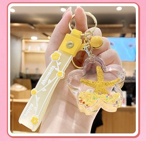 Macro shot of yellow flower liquid keychain featuring floating starfish and quicksand