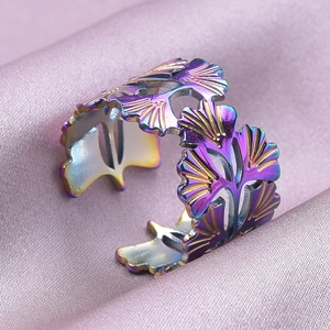 Macro d'une bague feuille de ginkgo arc-en-ciel sur un fond de soie violette douce