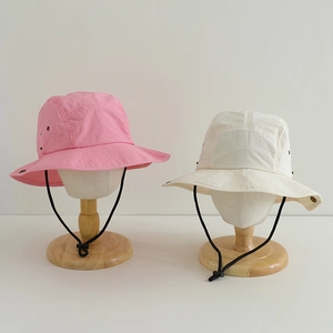 Detail of kids quick-dry bucket hats in pink and beige with adjustable windproof chin straps