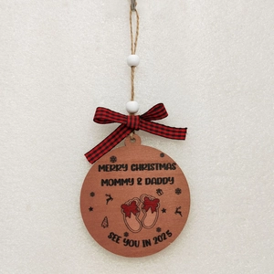 Close-up of wooden Christmas ornament with Merry Christmas 2025 engraving and bow