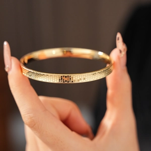Macro shot of gold textured concave bangle featuring detailed circular scale patterns