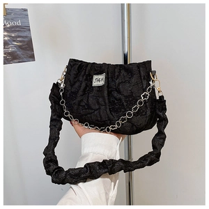 Close-up of black ruched cloud bag with metal chain strap and Jing Pin logo label