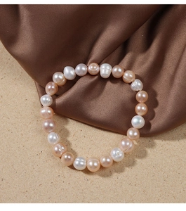 Detail view of multi-color baroque freshwater pearl bracelet on silk fabric background