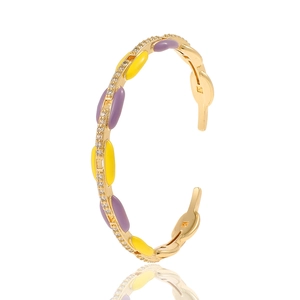 Detail of gold bangle with purple and yellow enamel inlays and sparkling zircon stones