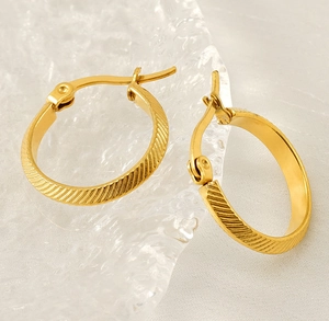 Detailed close-up of 18K gold-plated stainless steel earrings with diagonal stripe texture