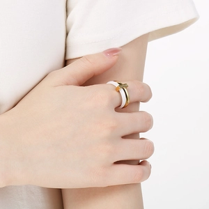 Detail of white ceramic and gold titanium ring with zircon-encrusted connecting beam