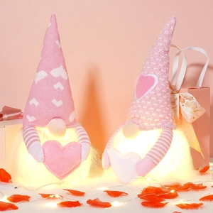 Close-up of glowing Valentine gnomes with knit hats and plush beards on rose petals