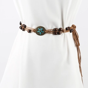Detail of woven brown rope belt with turquoise flower inlay on vintage bronze buckle