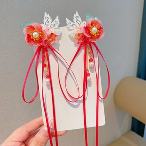 Detail of red flower hair clips with white wings, pearls and long tassels, 2-piece set