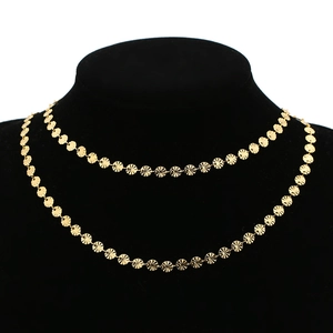 Close-up of golden sunburst disk chain displayed on a black velvet necklace bust