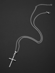 Collier avec pendentif croix argentée sur fond noir texturé avec un éclat métallique