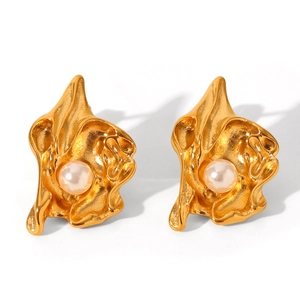 Macro detail of gold flower earrings featuring irregular shapes and white pearls