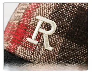 Close-up of checkered plaid wool baseball cap featuring large white letter R embroidery