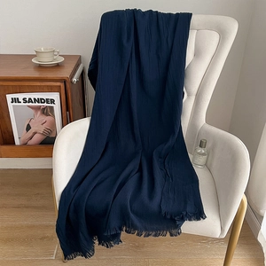 Deep blue cotton linen meditation shawl with fringe draped on a white chair
