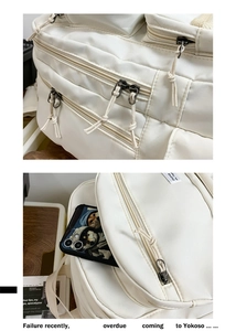 Detail of multi-pocket off-white nylon backpack with smooth zippers and sturdy stitching