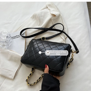 Detailed back view of the black quilted crossbody bag with gold chain strap on a blazer