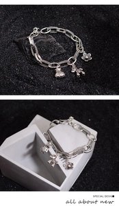 Detail view of vintage silver chain bracelet with flower, money bag, and horse charms