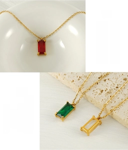 Detail of 18K gold stainless steel necklace with square cut gemstones in red and green