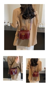 Detail view of the vintage wine red leather bucket bag with elegant gold hardware accents