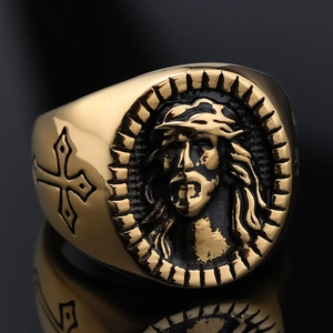 Macro shot of gold embossed Jesus portrait and side cross on vintage stainless steel ring