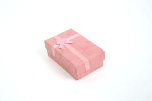 Detail view of pink jewelry gift box with matching ribbon bow on white background