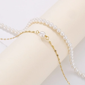Detail of double-layer necklace featuring white pearls and golden metallic chain link